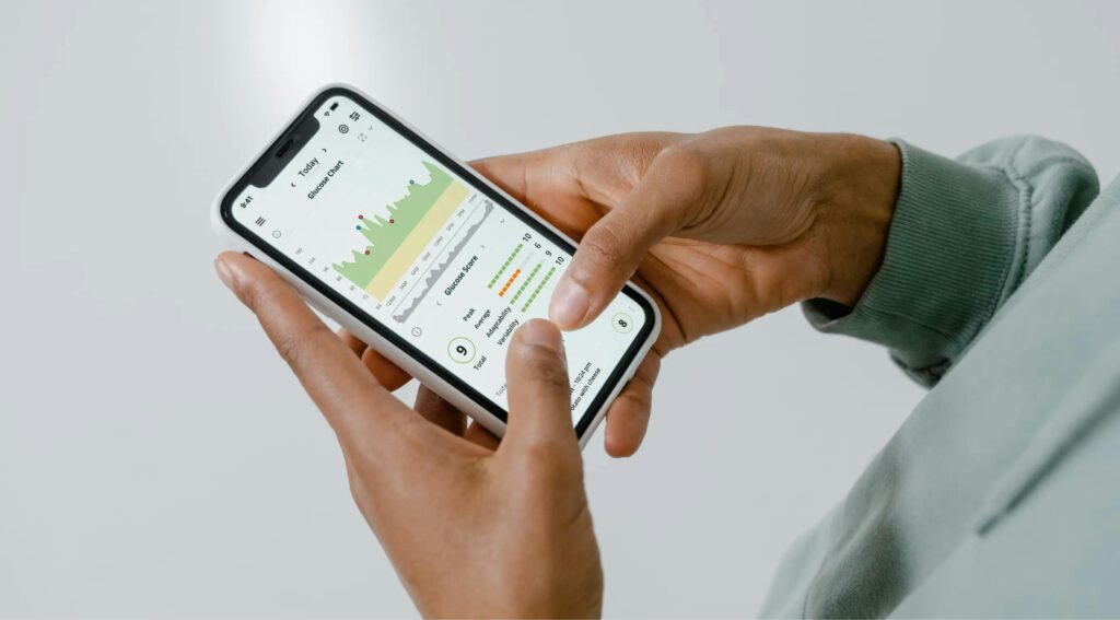pexels-photo-17947753-17947753 Close-up of hands holding a smartphone showing a health tracking app with charts and data.